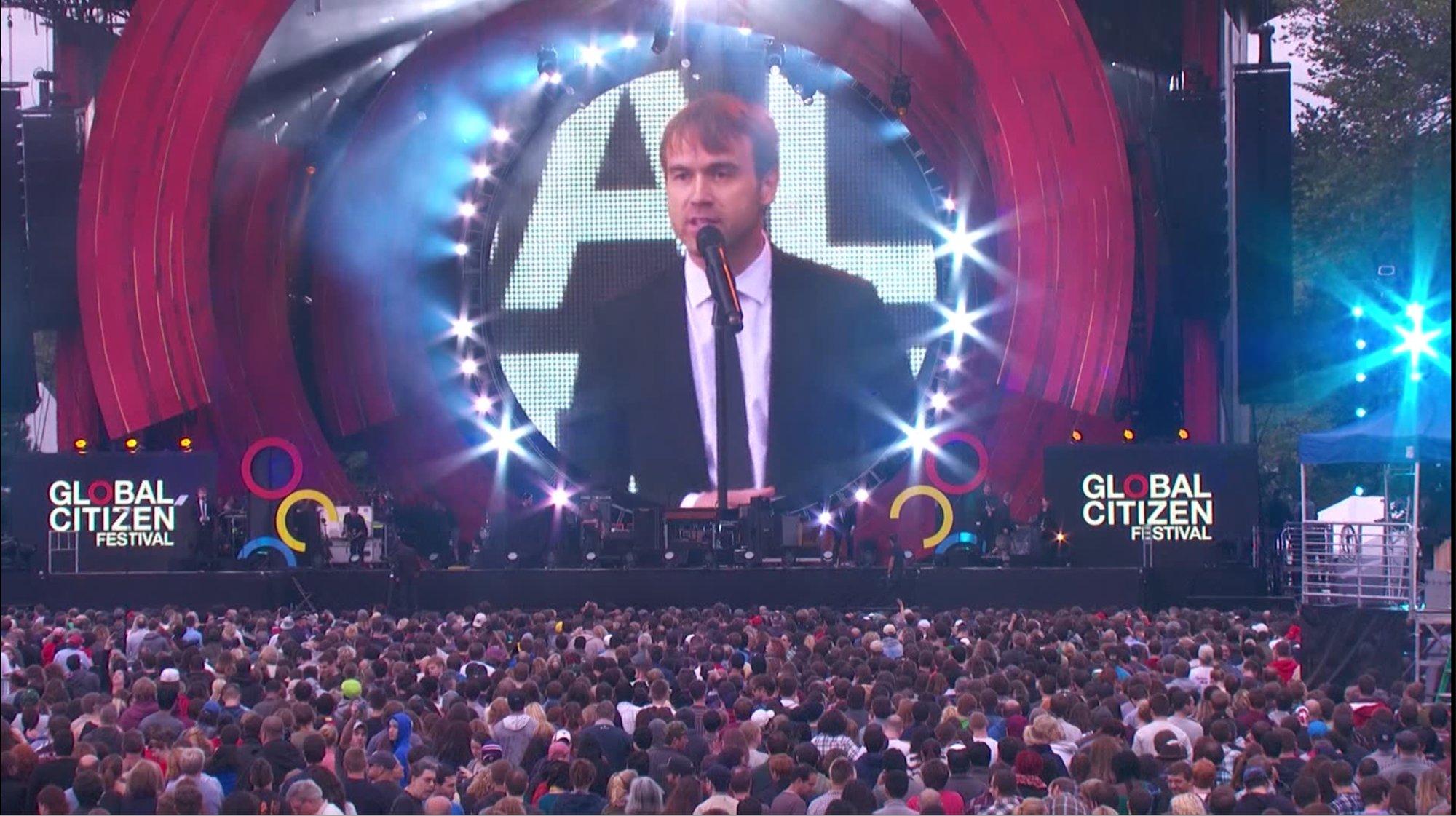 Michael Trainer speaking on stage at the Global Citizen Festival